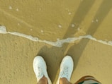 A pair of lightweight, water-resistant slip-ons on a sandy beach.