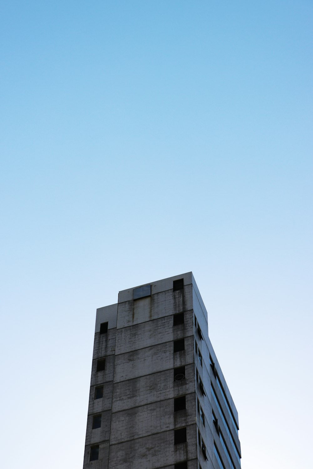 a tall building with a plane flying in the sky