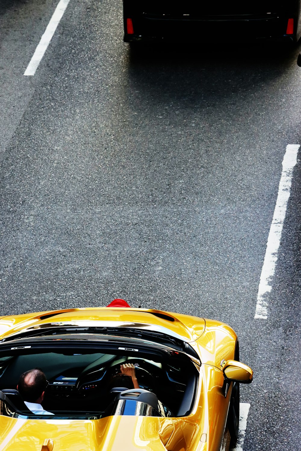Une voiture de sport jaune roulant dans une rue