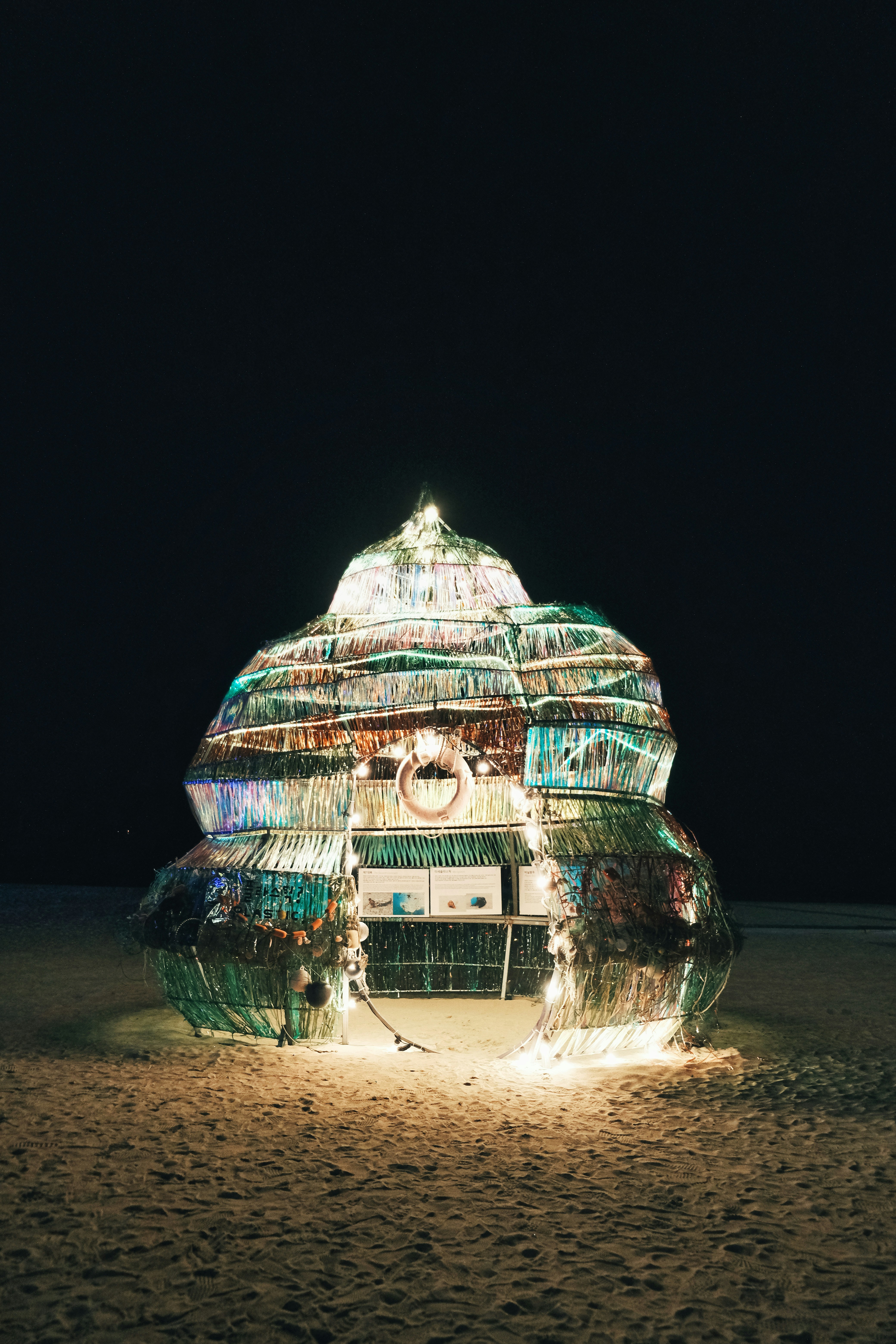 Un edificio fatto di bottiglie di plastica su una spiaggia