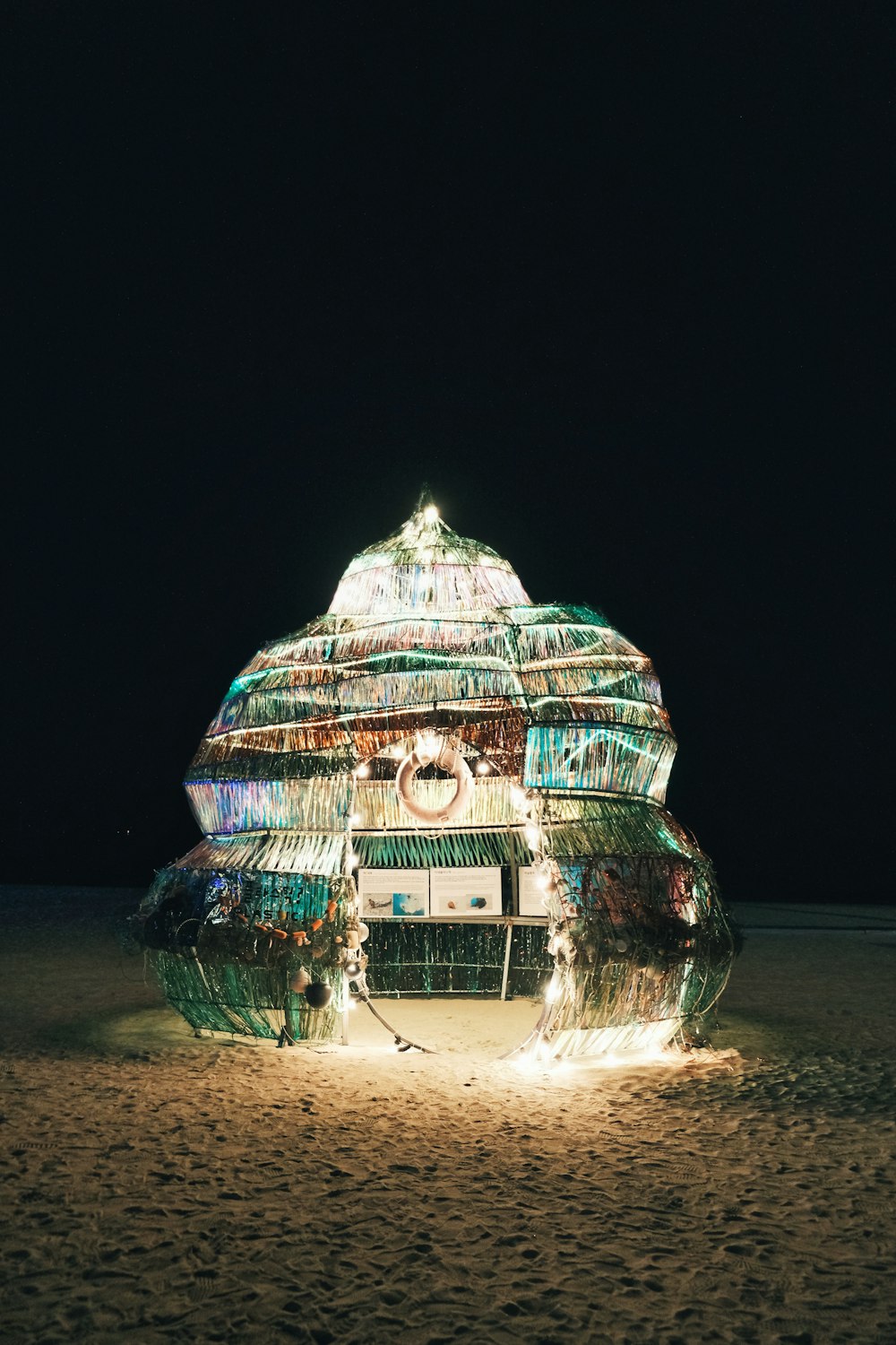 a building made out of plastic bottles on a beach