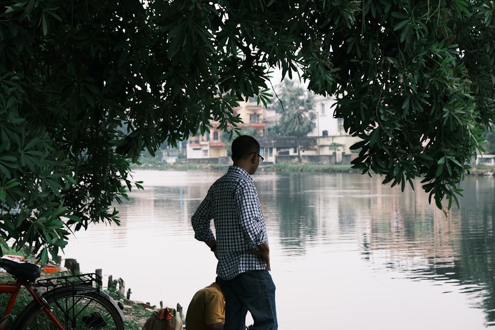 a man standing next to a body of water