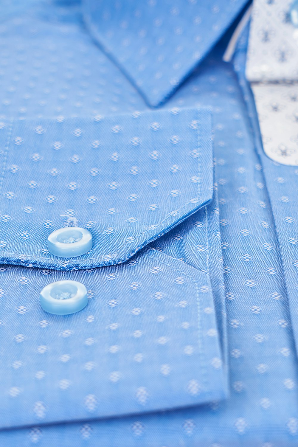 a close up of a blue shirt with buttons