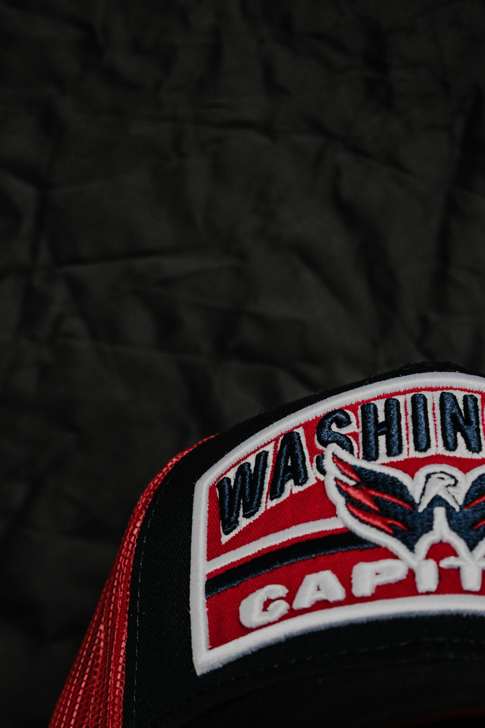 a black and red hat with a washington gaffe patch on it