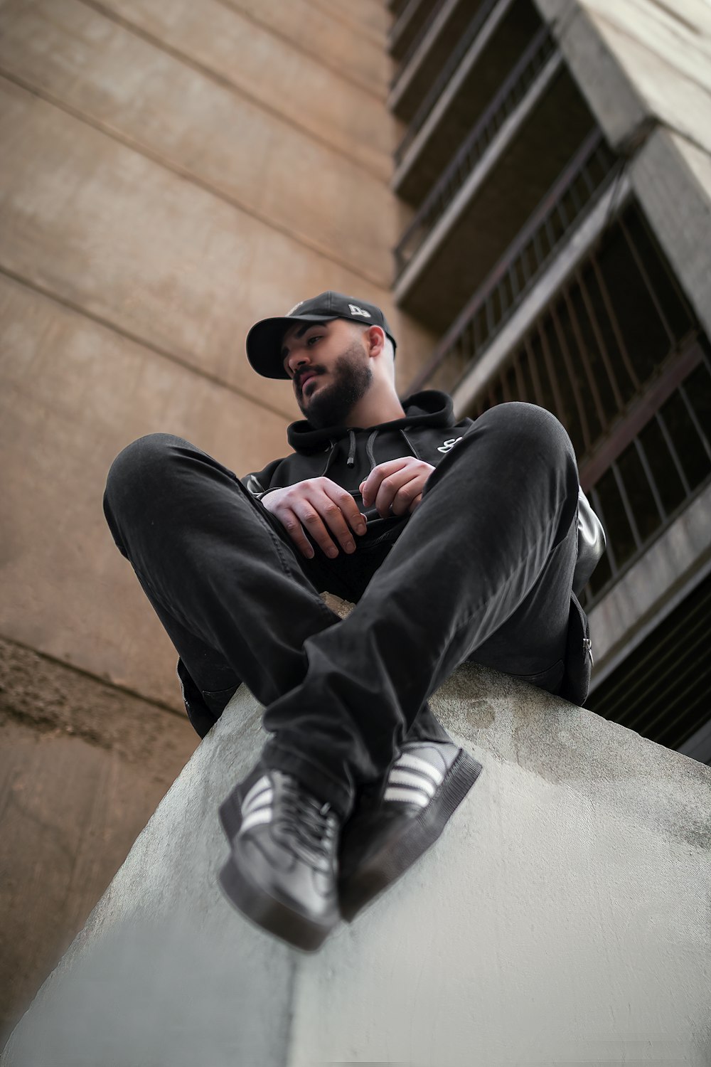 a man sitting on the side of a building