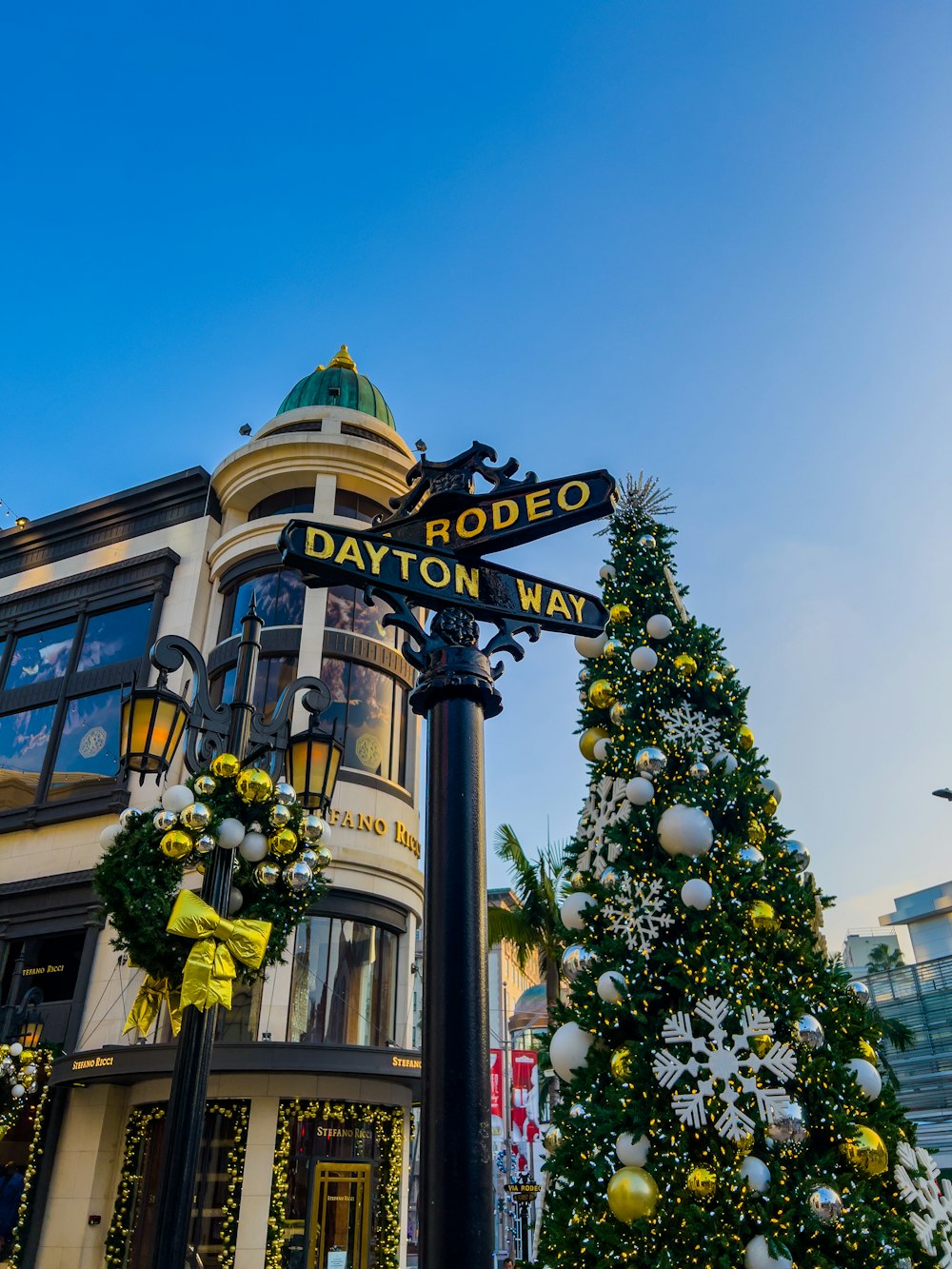 uma árvore de Natal e sinal de rua em frente a um edifício