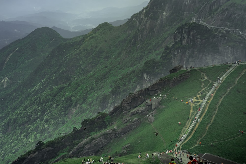 Un grupo de personas de pie en la cima de una exuberante ladera verde