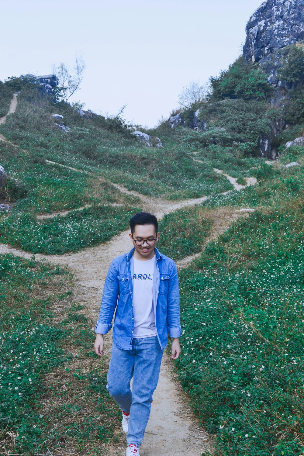 a man in a blue jacket is walking on a path