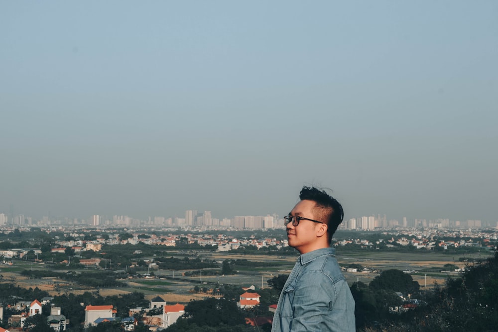 a man standing on top of a hill overlooking a city