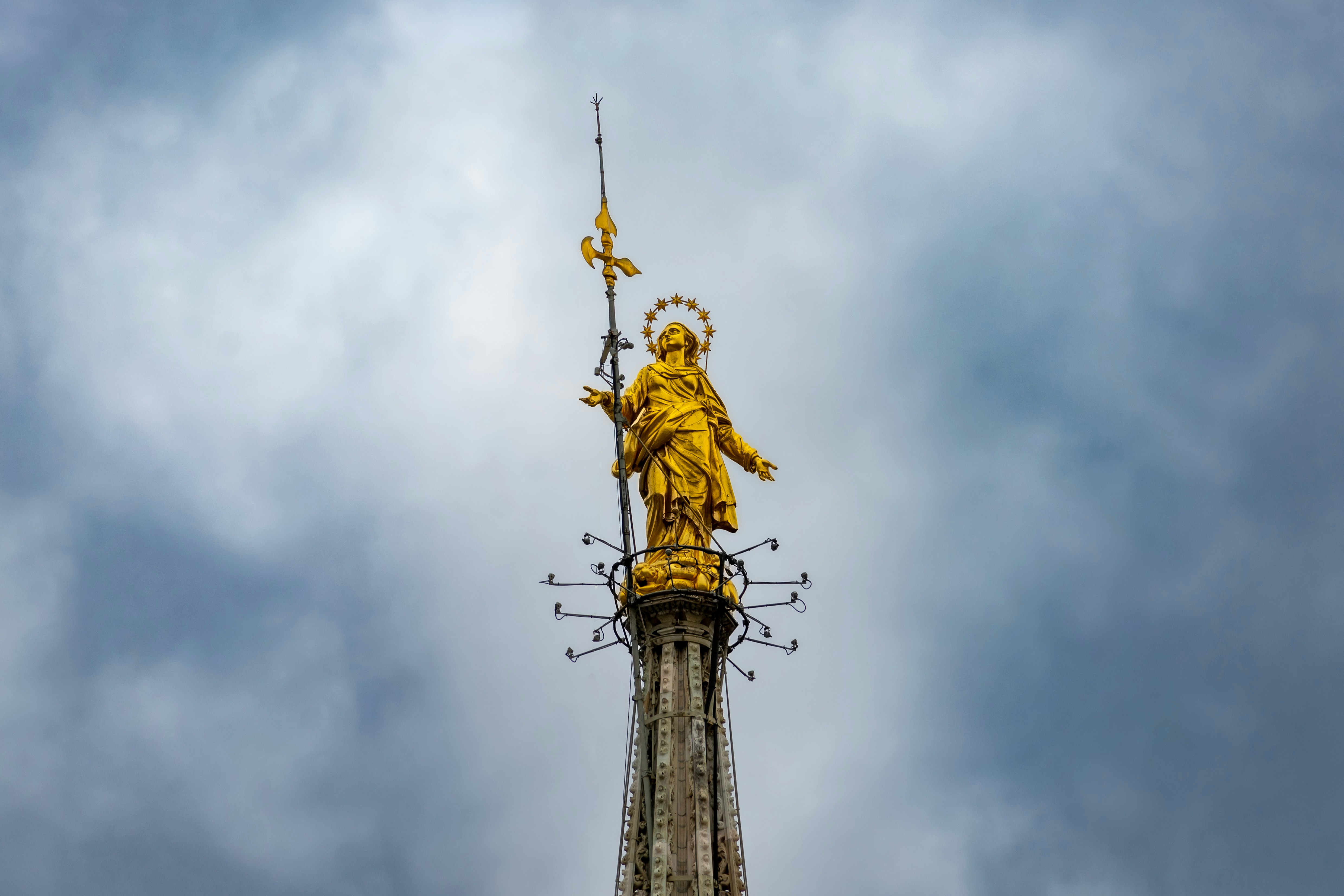 a golden statue on top of a tall building, 