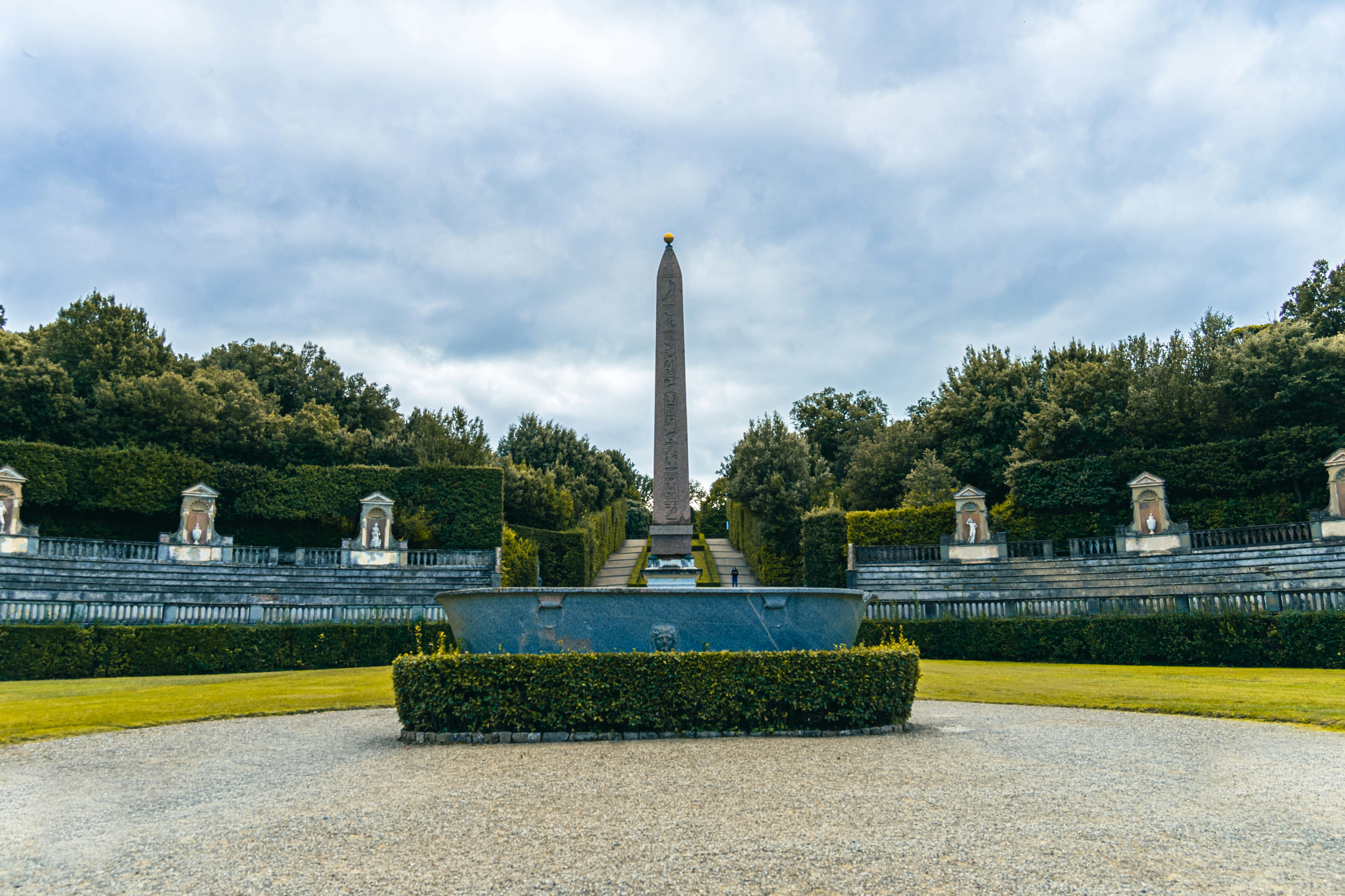 a fountain in the middle of a park with a monument in the background