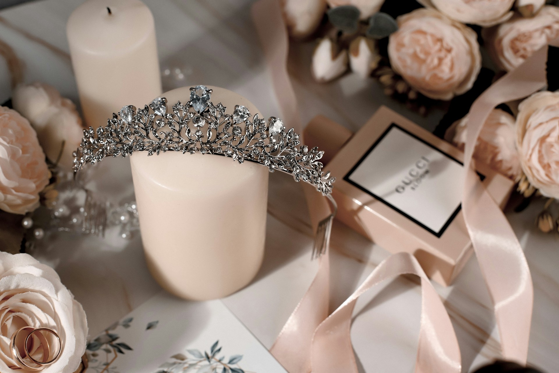 a tiara sitting on a table next to a candle and flowers