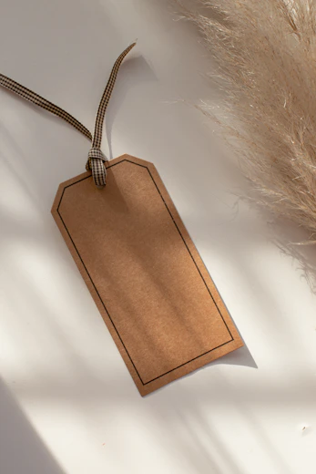 a brown tag hanging from a string on a table
