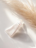 a bottle of perfume sitting on top of a white table