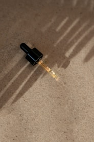 a small black object with a long shadow on the ground