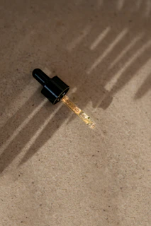 a small black object with a long shadow on the ground