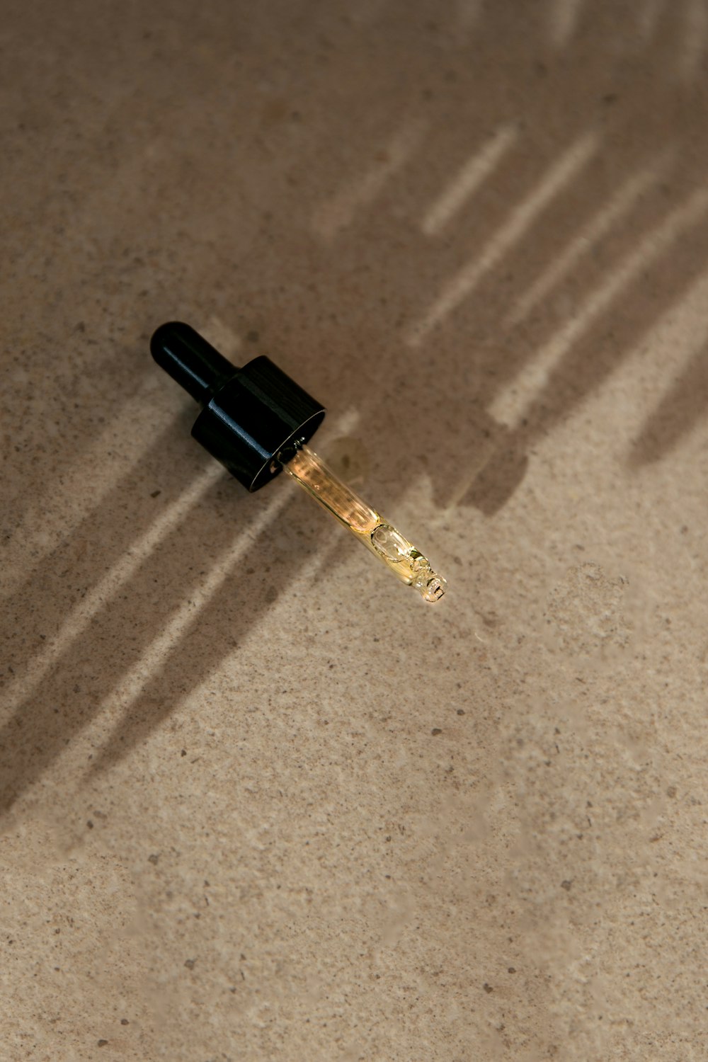 a small black object with a long shadow on the ground