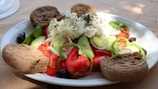 a white plate topped with a salad and bread