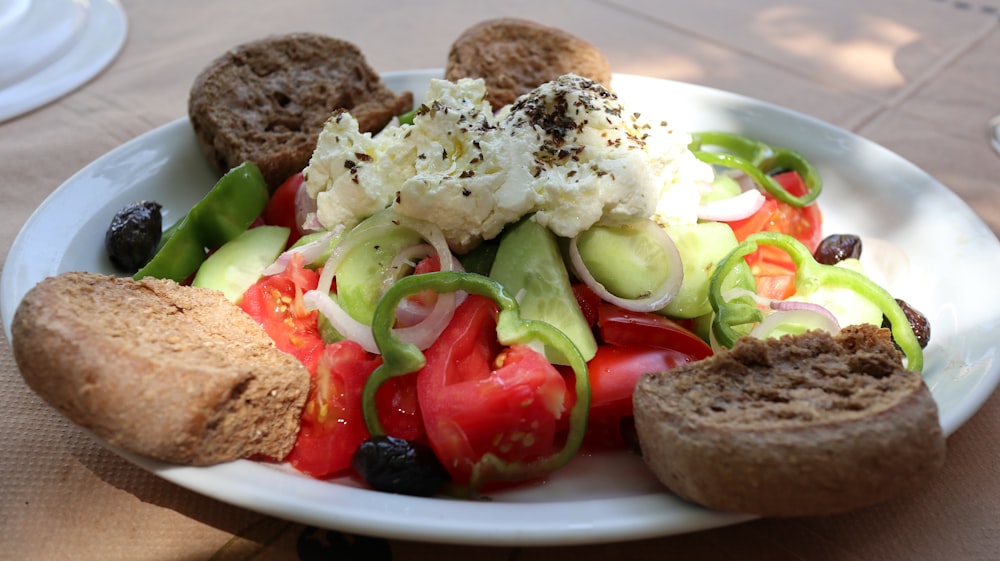 a white plate topped with a salad and bread