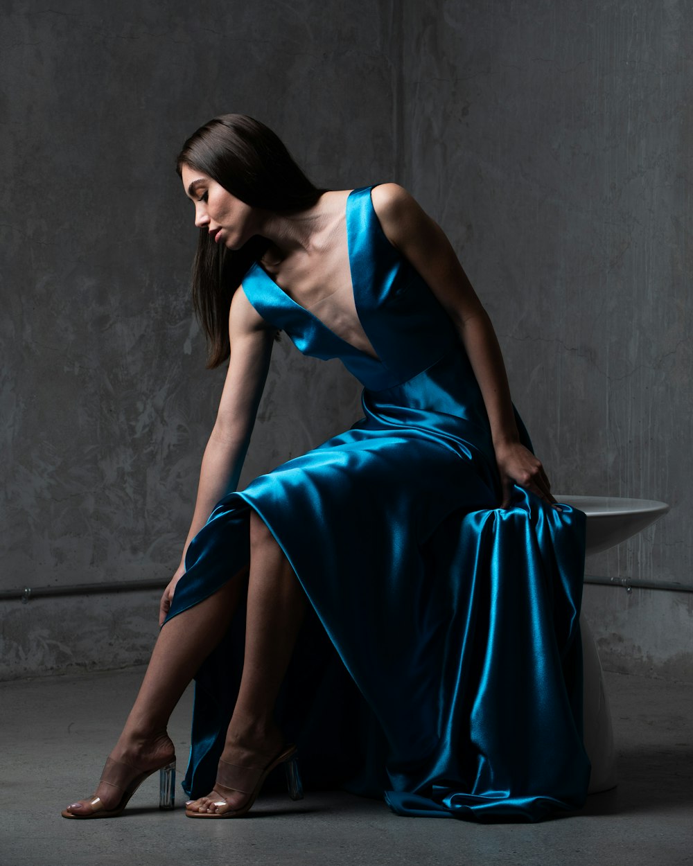 a woman in a blue dress sitting on a table