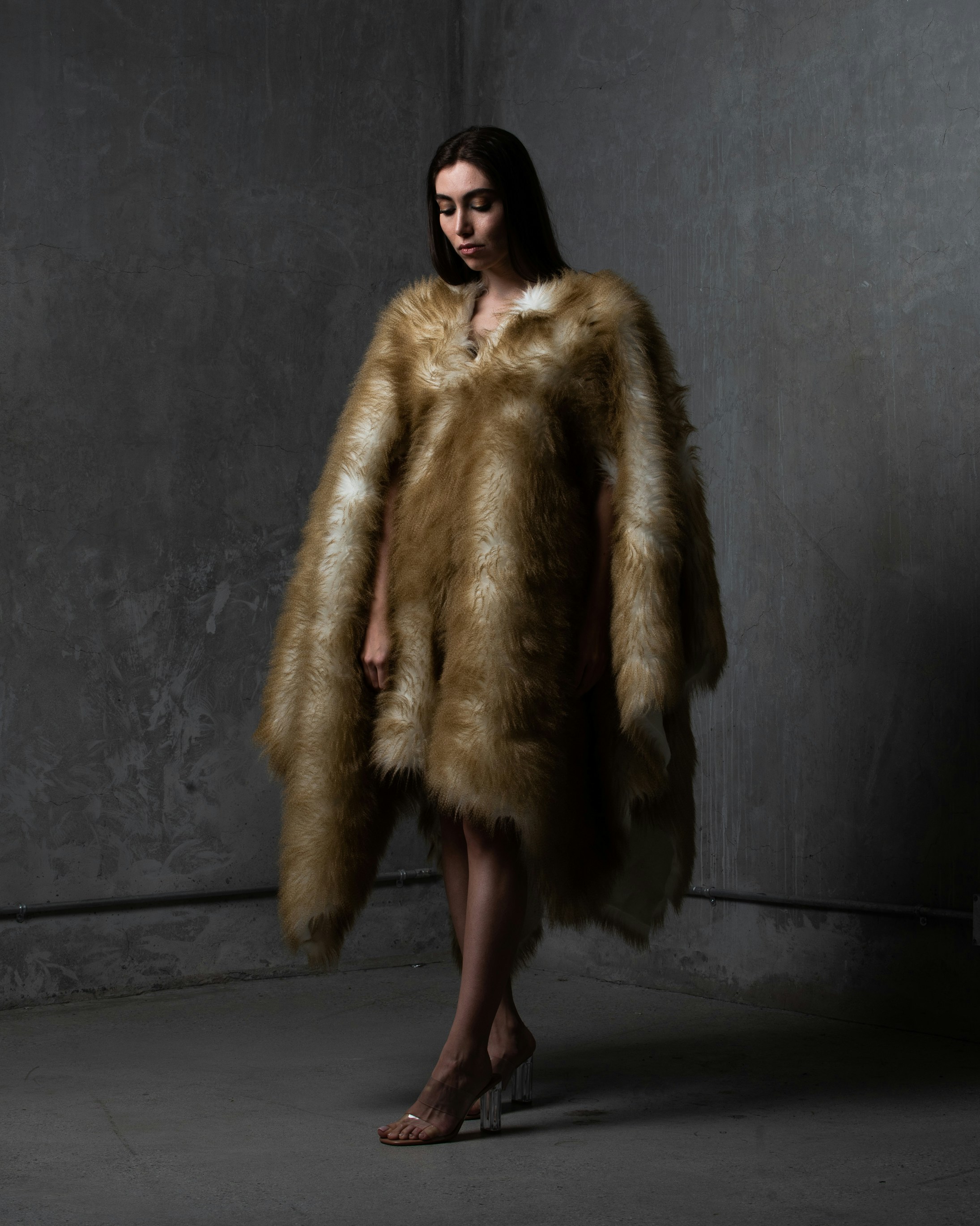 a woman in a fur coat standing in a dark room