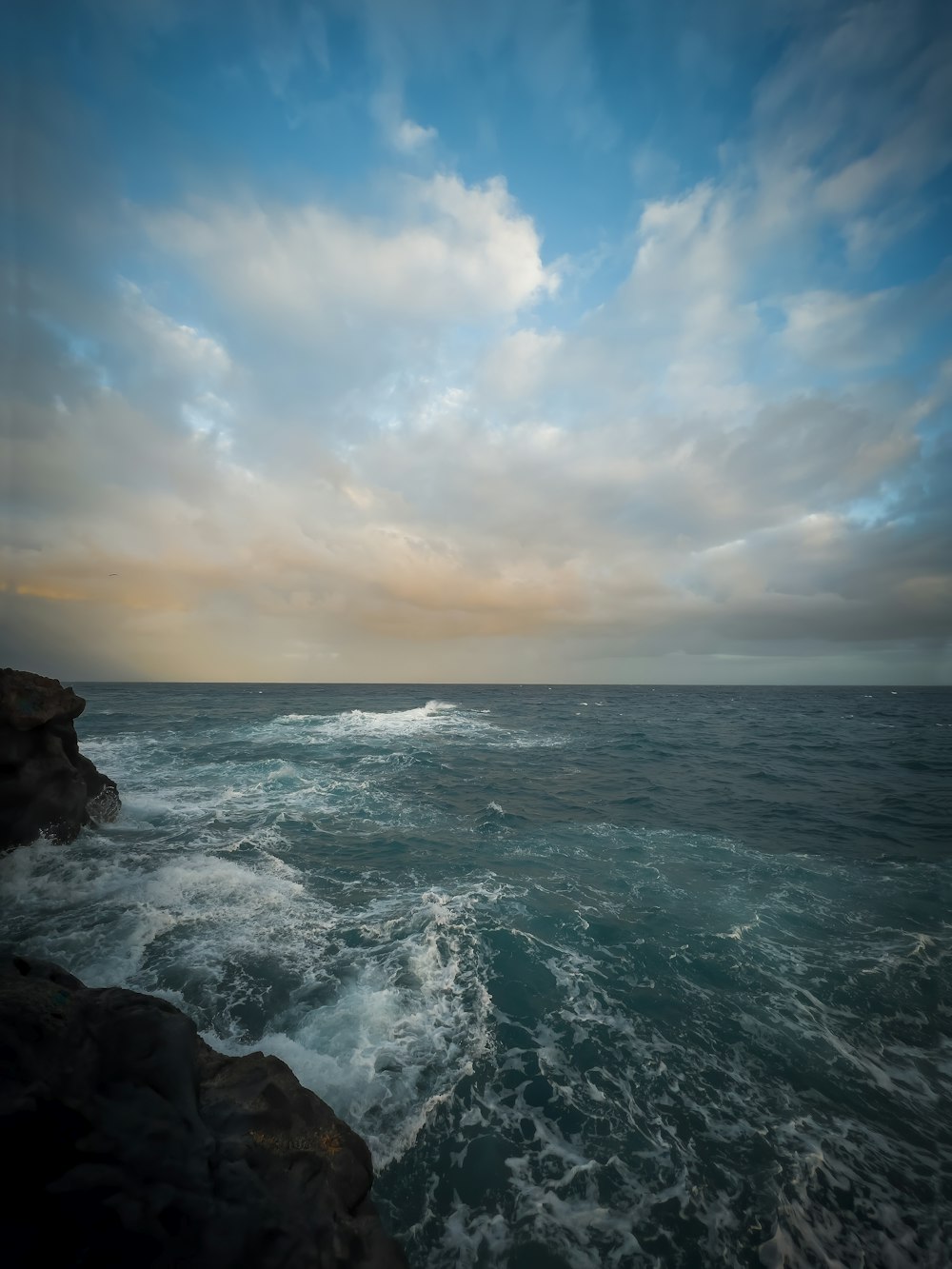 a view of the ocean from a rocky shore