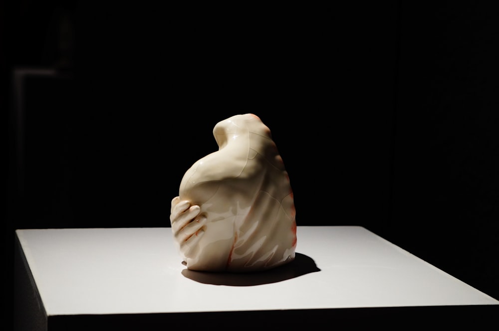 a white sculpture sitting on top of a white table