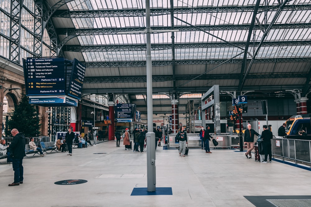 a group of people standing around a train station