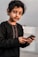 a young boy holding a smart phone in his hands