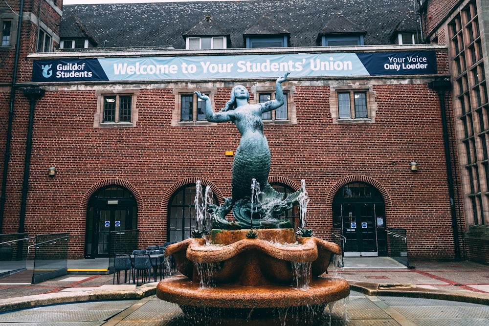 a water fountain in front of a brick building