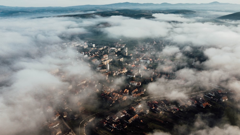 an aerial view of a city surrounded by clouds