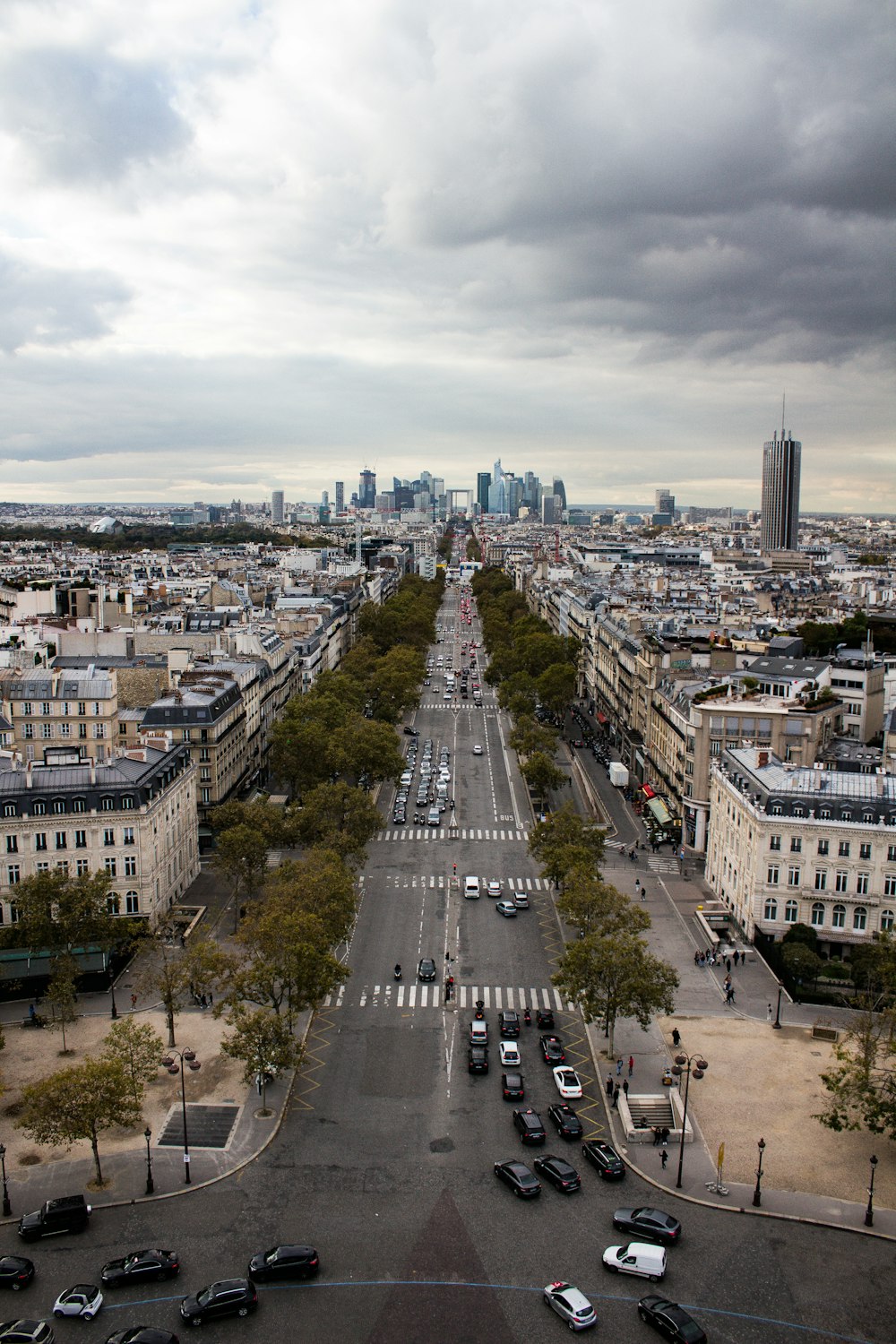 an aerial view of a city street with cars parked on both sides of the street