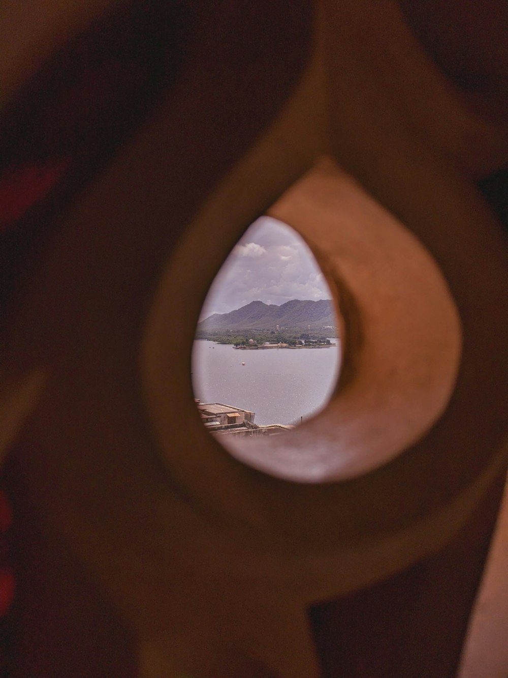 a view of a body of water through a hole in a wall