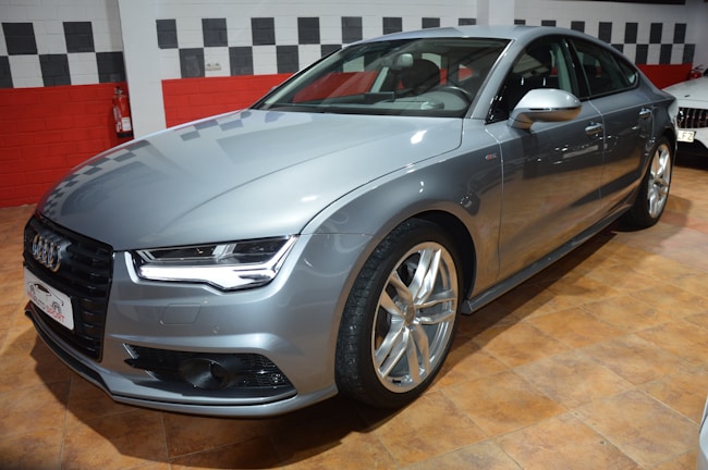 Sleek silver Continental luxury sedan parked under soft showroom lighting.
