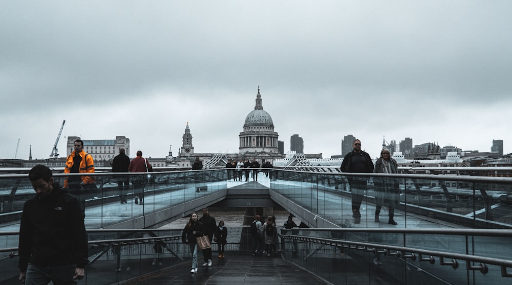 a group of people walking across a bridge