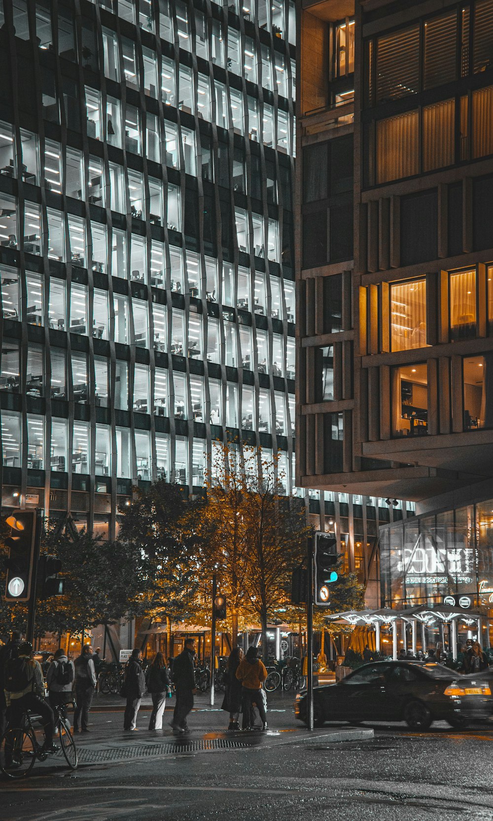 a group of people crossing a street in front of a tall building