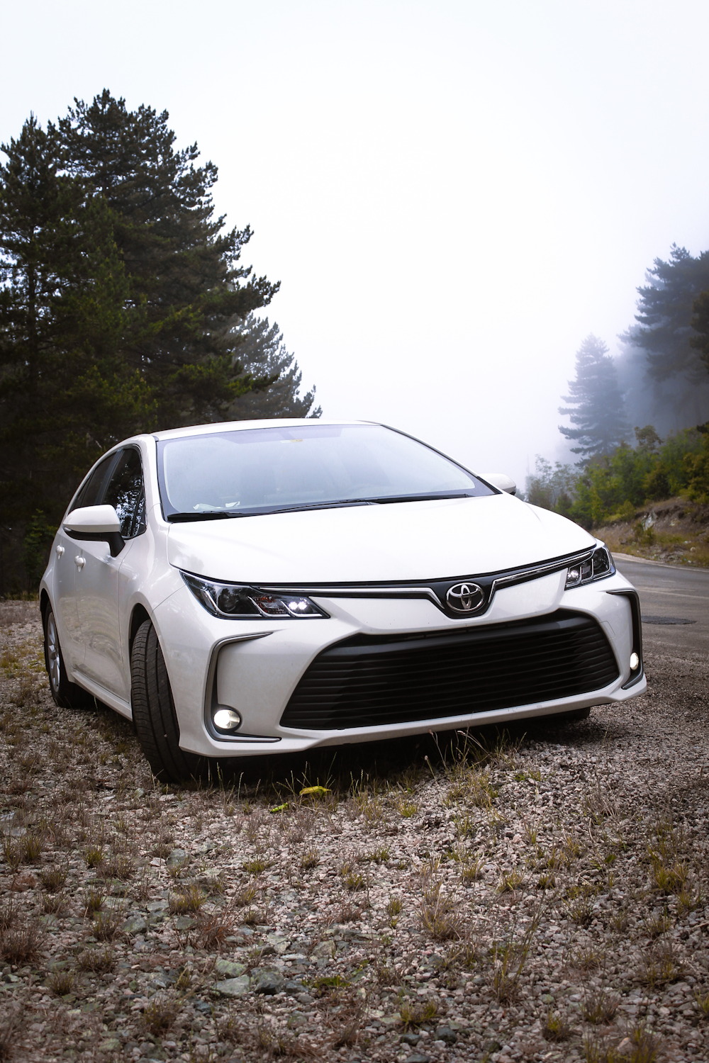 um carro branco estacionado na beira de uma estrada