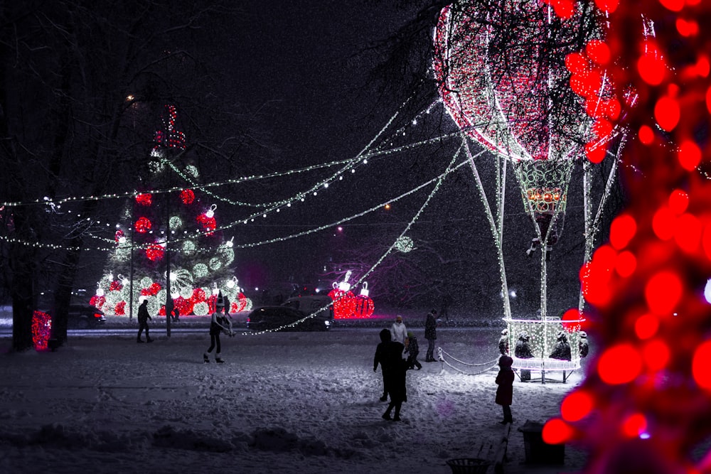 a group of people walking around a park at night