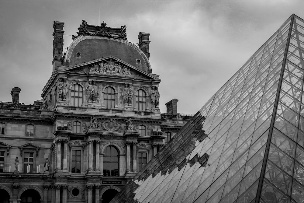 建物とガラスピラミッドの白黒写真