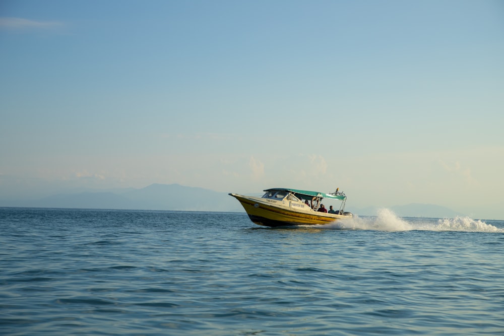 um barco amarelo com pessoas sobre ele na água