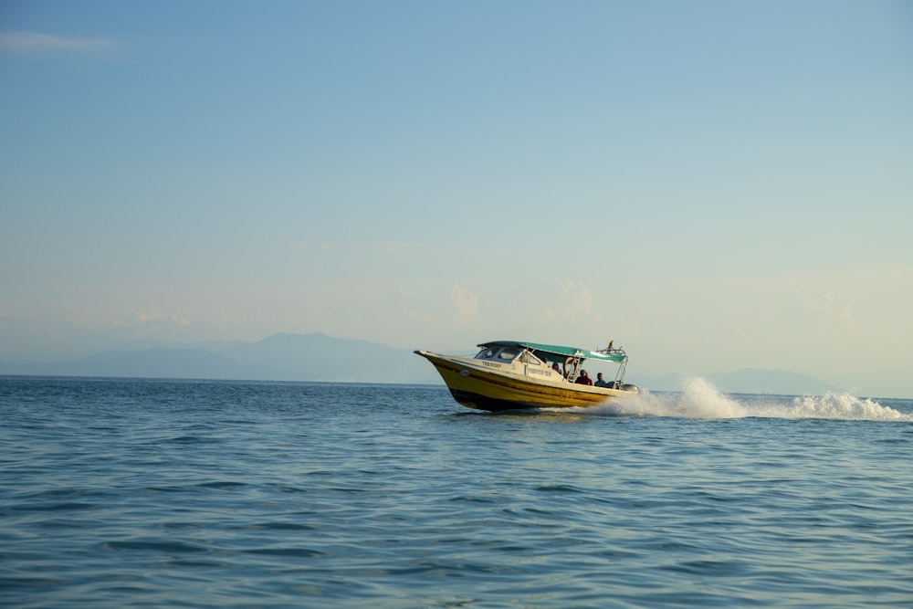 a yellow boat with people on it in the water