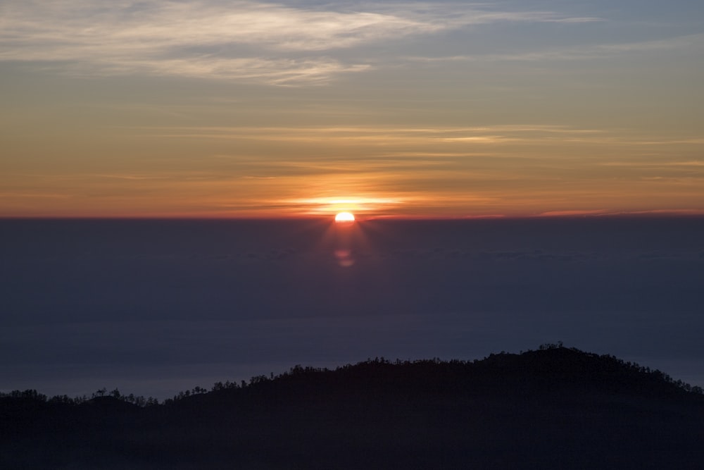 the sun is setting over the clouds in the sky