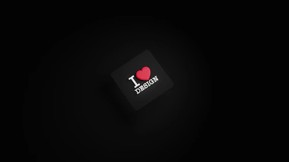 A dark background with a black square in the center. The square has the text 'I ❤️ DESIGN' with the heart symbol in red color.