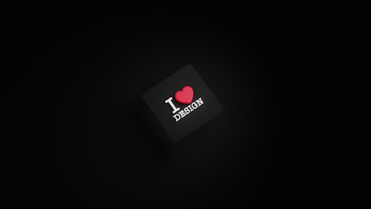 A dark background with a black square in the center. The square has the text 'I ❤️ DESIGN' with the heart symbol in red color.