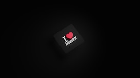 A dark background with a black square in the center. The square has the text 'I ❤️ DESIGN' with the heart symbol in red color.