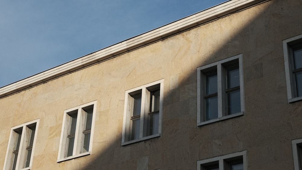 a building with three windows and a clock on the side of it