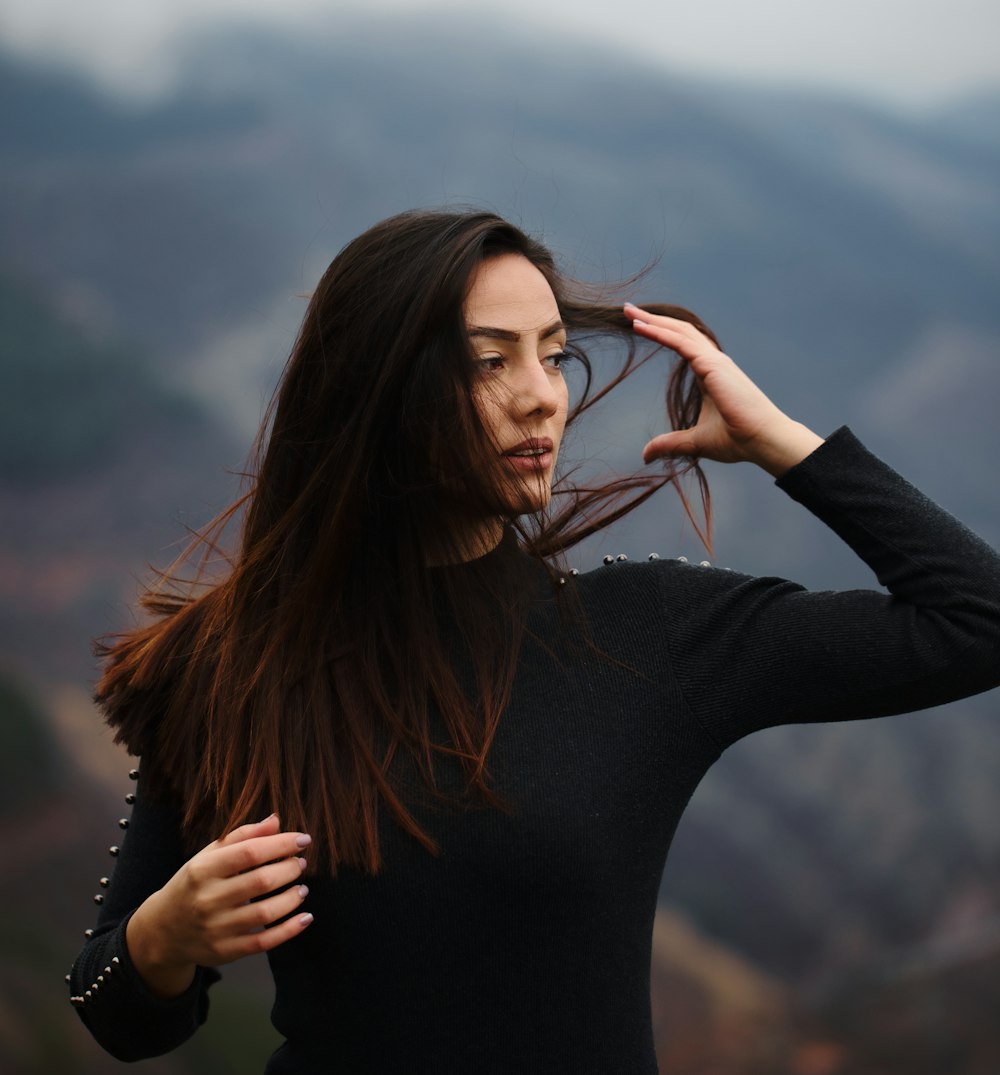 a woman holding her hair in the wind