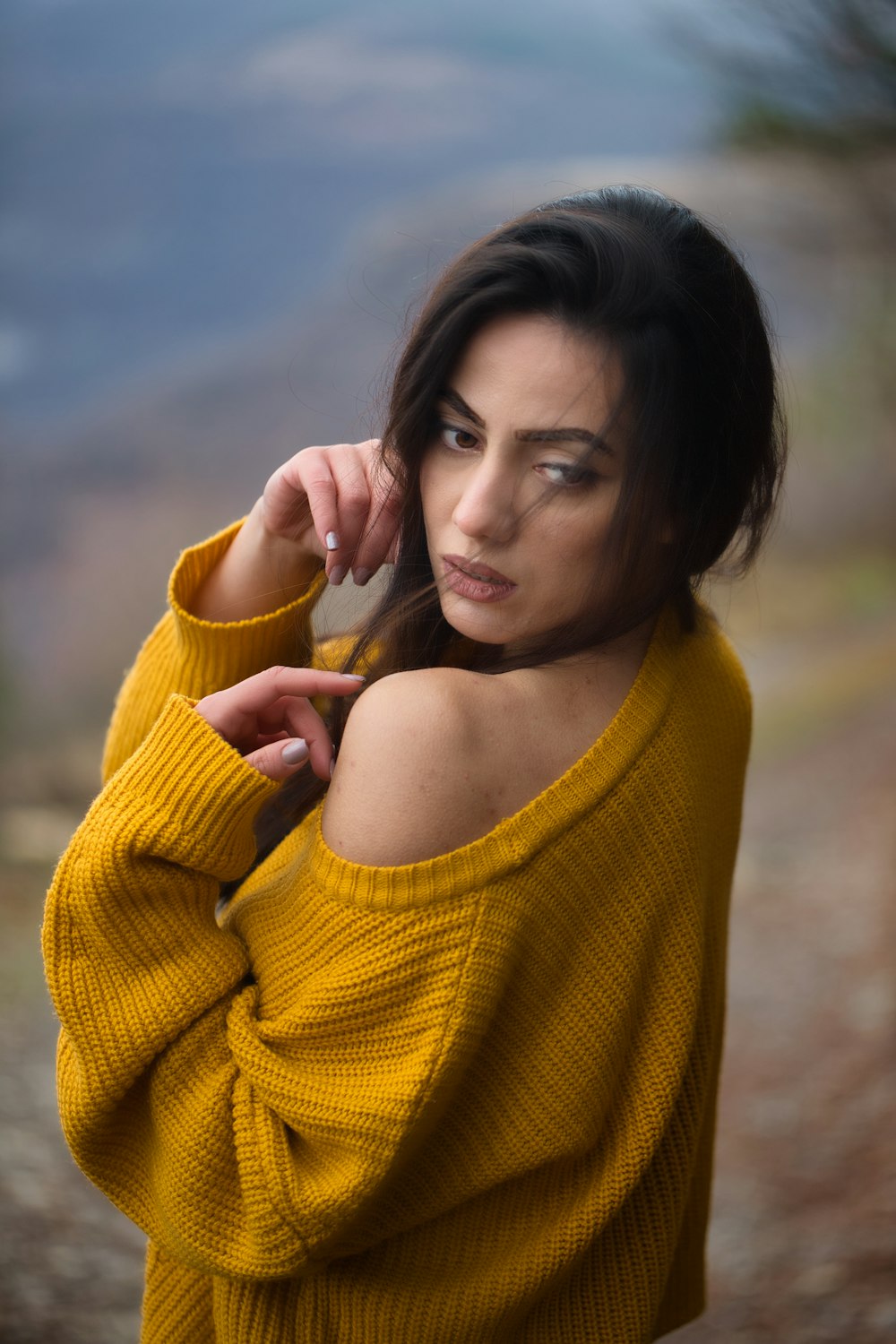 a woman in a yellow sweater posing for a picture