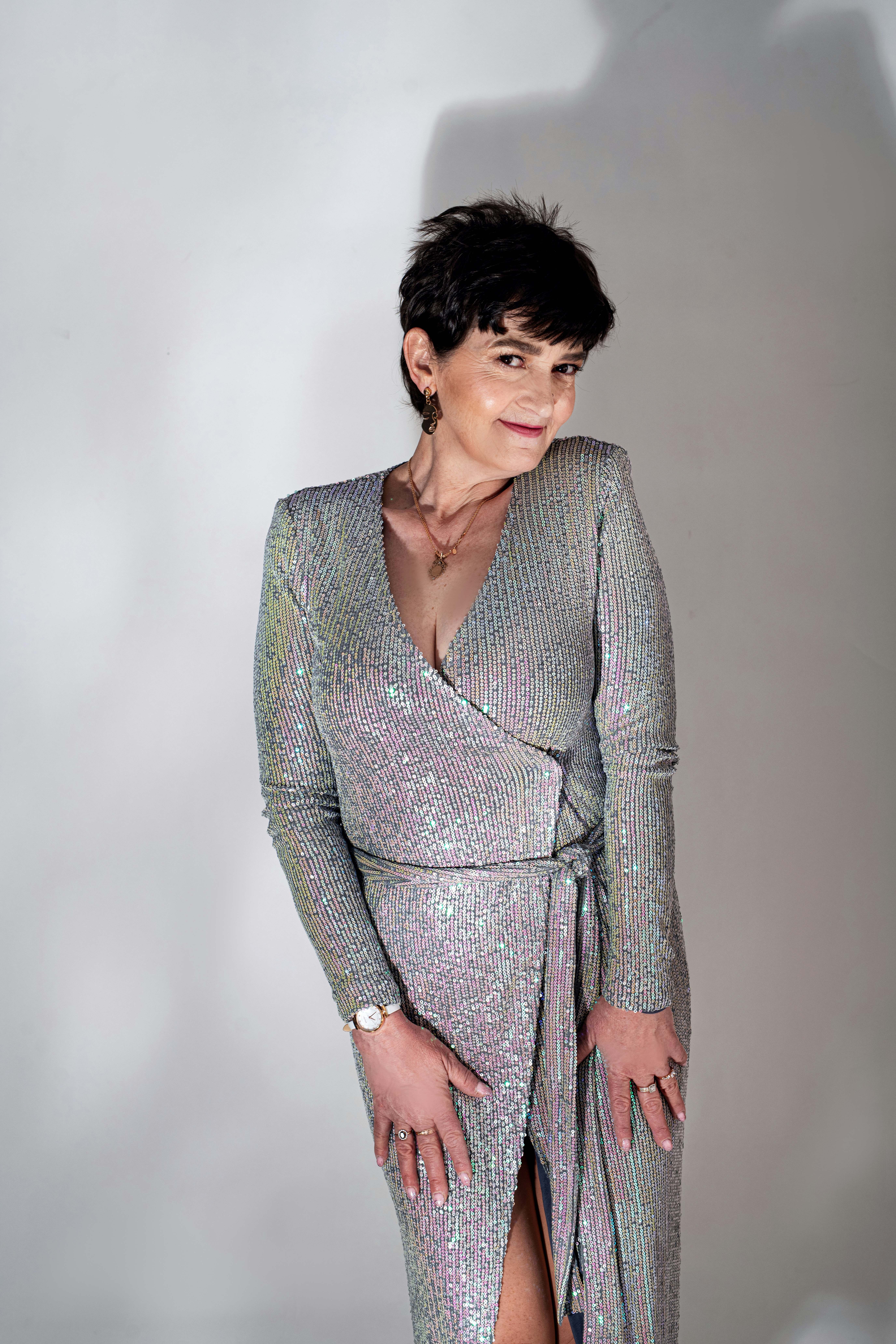 Eine Frau in einem silbernen Kleid posiert für ein Foto