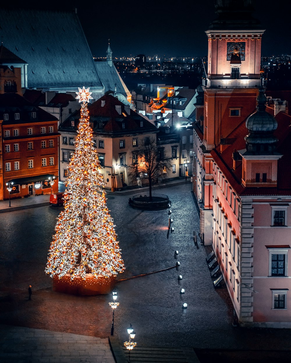 a lit christmas tree in a city square